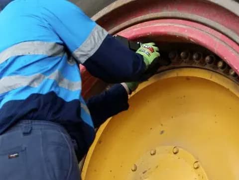 A tyre fitter installing a Rim-UnLock® retainer over an exposed stud