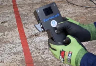 The Rim-UnLock® remote controller held in a gloved hand